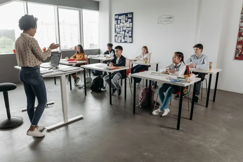 Workshop im Klassenraum: Eine Trainerin spricht mit einer Gruppe Jugendlicher